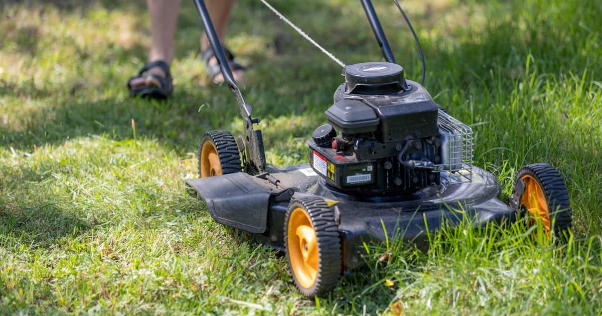 A person mowing the grass with a lawn mower